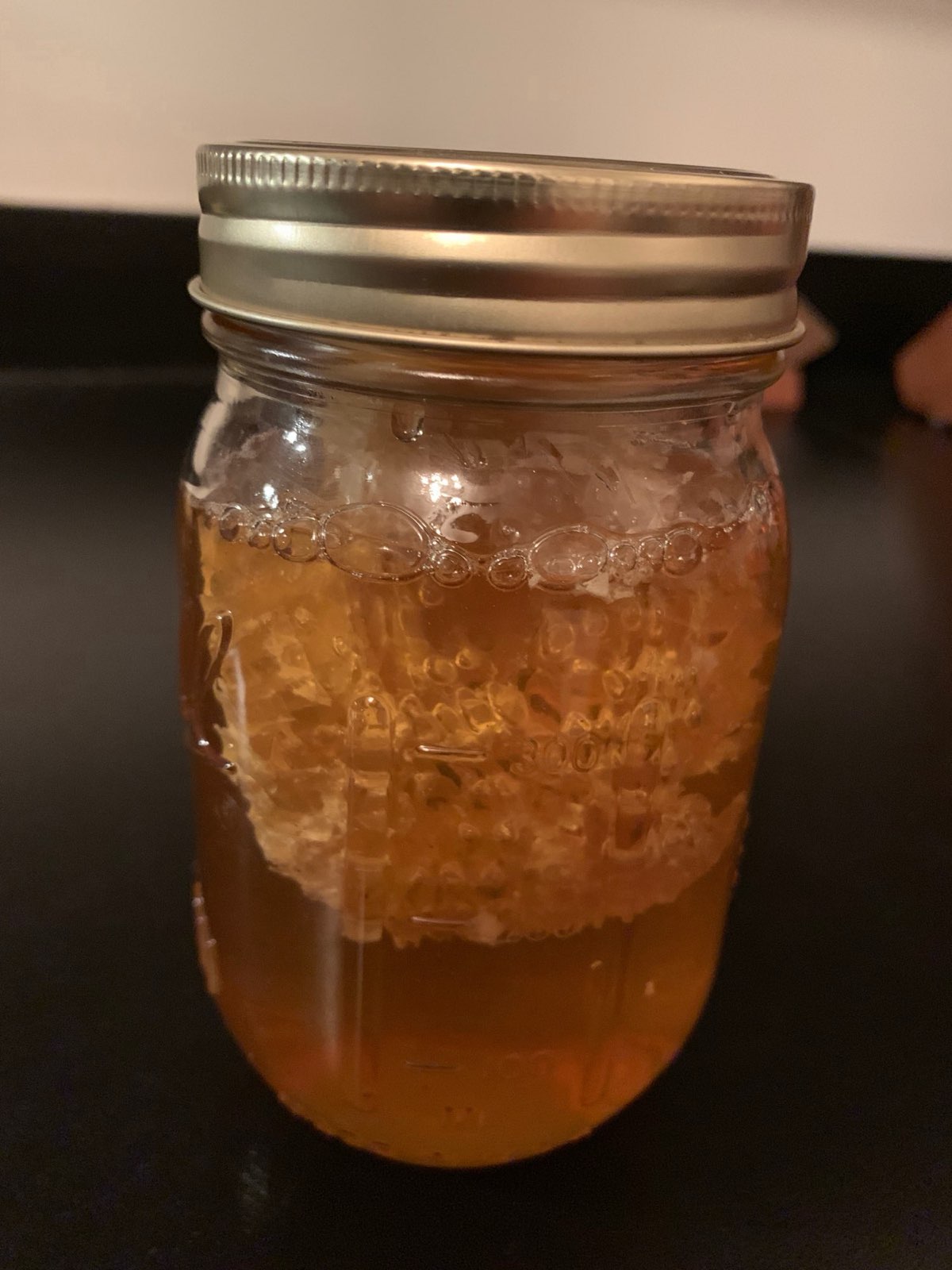 A jar of chunk honey with a piece of comb inside in Central PA