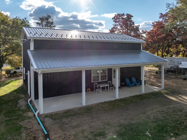 The front of The Honey House — a modern dark barndominium with a metal roof and covered patio, on The Alleman Apiary property in Harrisburg, PA